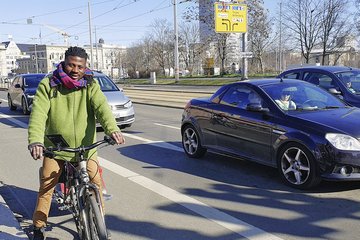 zusehen: ein Radfahrer der an der Ampel, steht auf dem großzügigen Radstreifen  