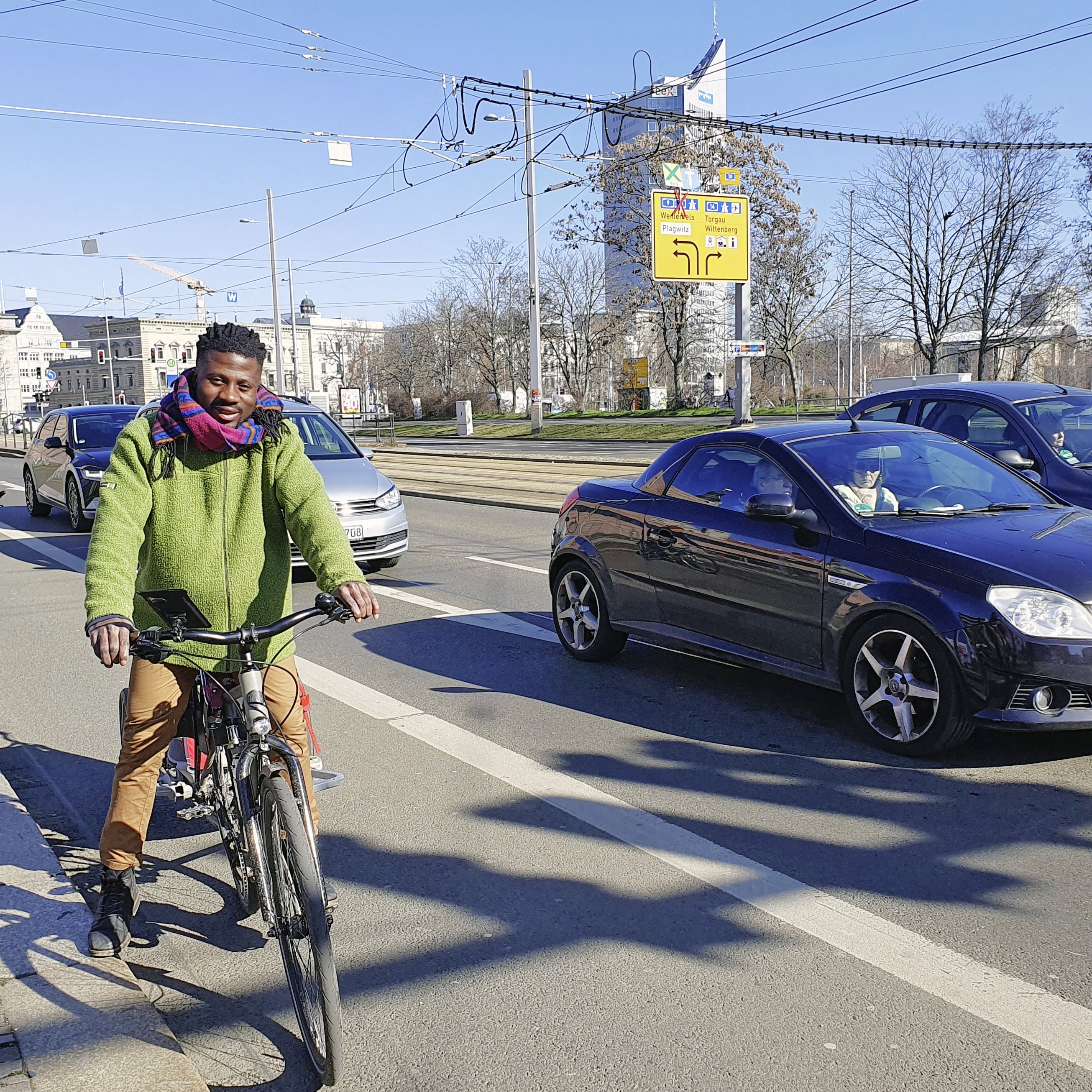 zusehen: ein Radfahrer der an der Ampel, steht auf dem großzügigen Radstreifen  