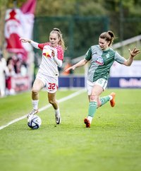 Mia Werner, dribbelt an der Seitenlinie einen Gegenspielerin des Werder Bremern aus  