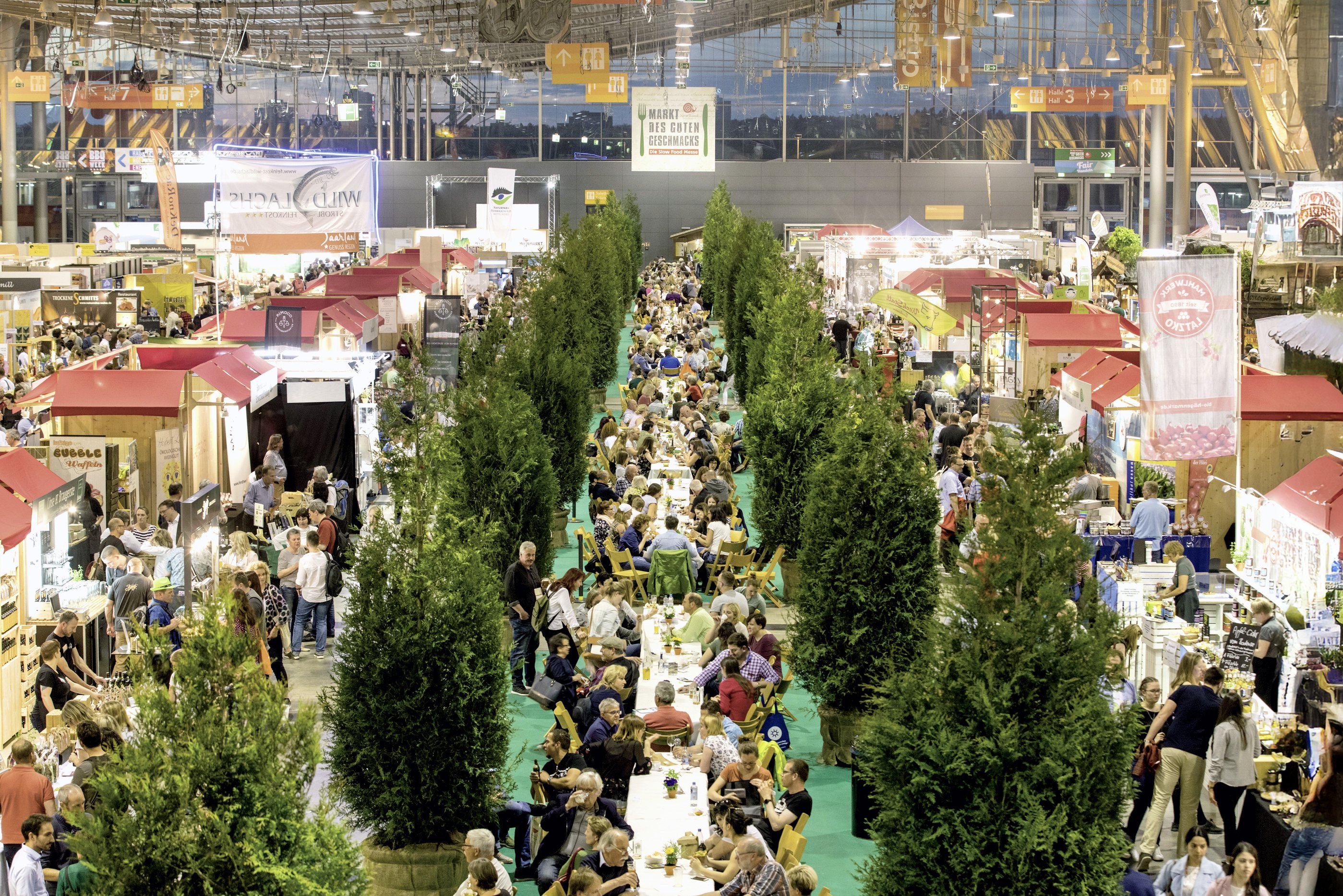 Besucher genießen den Slow-Food- Markt in geselliger Atmosphäre