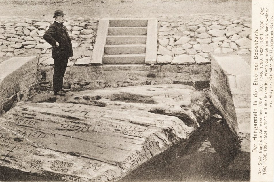 Eine historische Postkarte zeigt einen sogenannten Hungerstein bei Niedrigwasser
