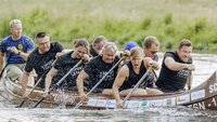 9 Menschen rudern kraftvoll ein Boot 
