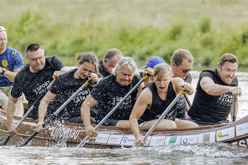 9 Menschen rudern kraftvoll ein Boot 
