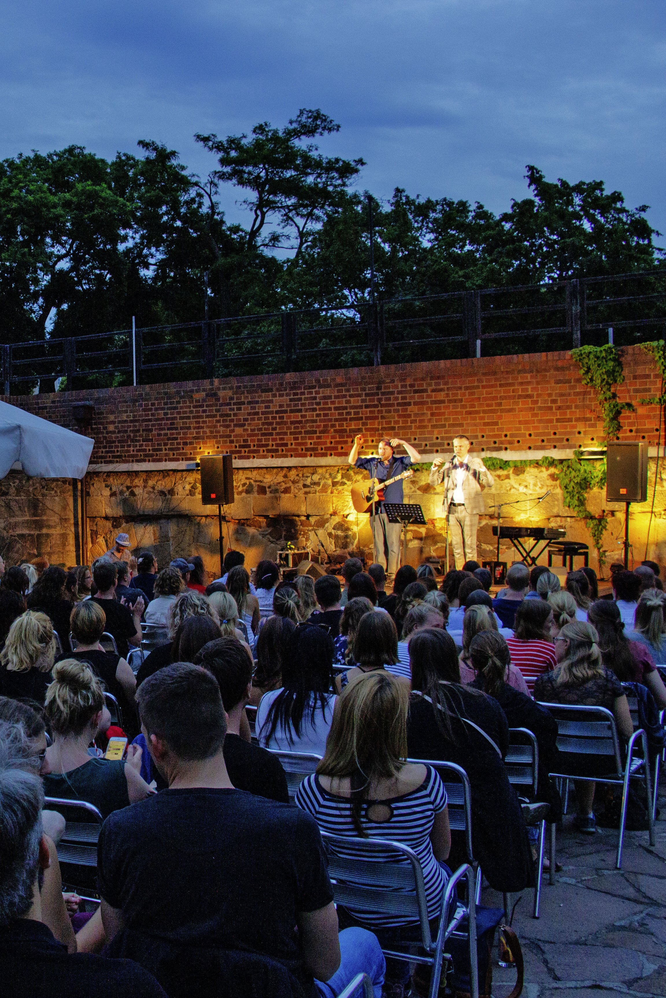 zusehen ist einen Konzert. die Bühne ist mit gelben Scheinwerferlicht beleuchtet. 