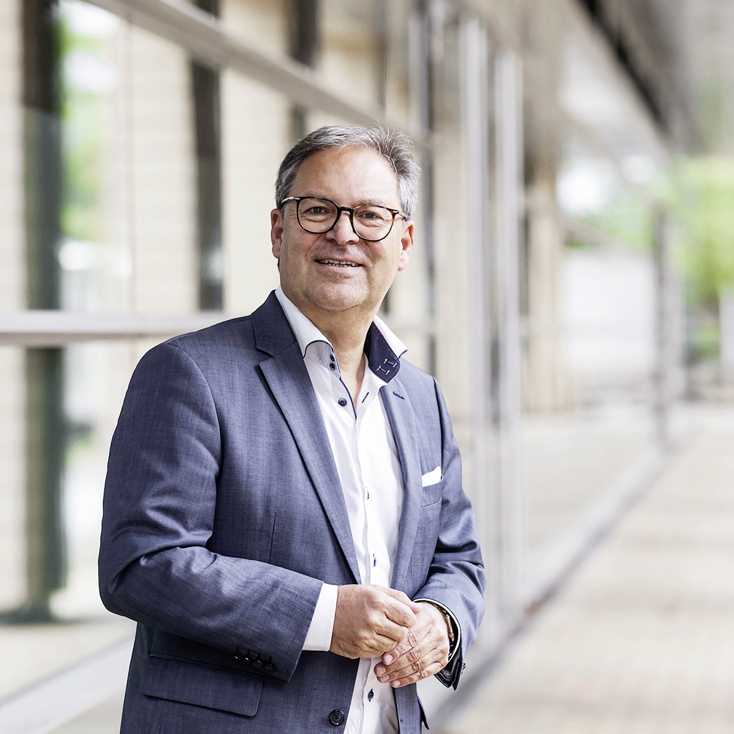 Foto von Hermann Winkler im Hintergrund ein Glasfront 