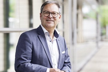Foto von Hermann Winkler im Hintergrund ein Glasfront 
