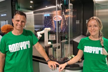 Christian Schneider (l.) und seine Frau stehen im Roboter-Foodspot Robyn's in den Leipziger Bahnhofspassagen.