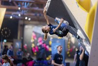 Boulder, eine junge Frau hängt kopfüber an der Kletterwand 