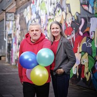 zwei Menschen mit Luftballons in der Hand 