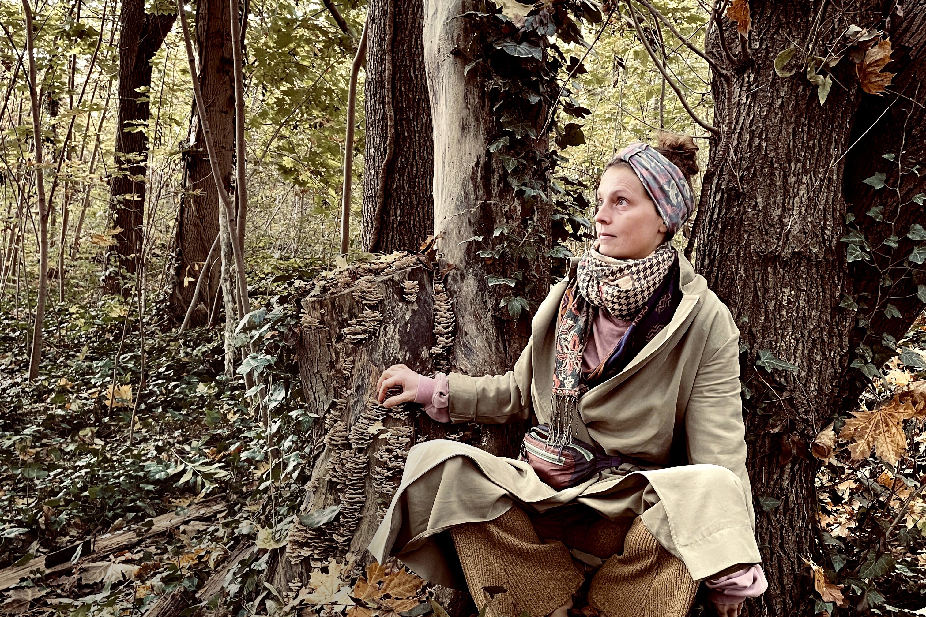 Frau sitzt im Wald