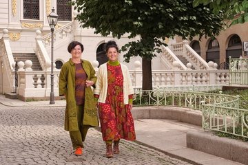 Die Muster auf Sylvias (re.) Kleid „Kiara“ fangen den Dschungel nach dem Monsunregen ein. Marion trägt das bestickte Kleid „Fields“ mit der passenden Hose