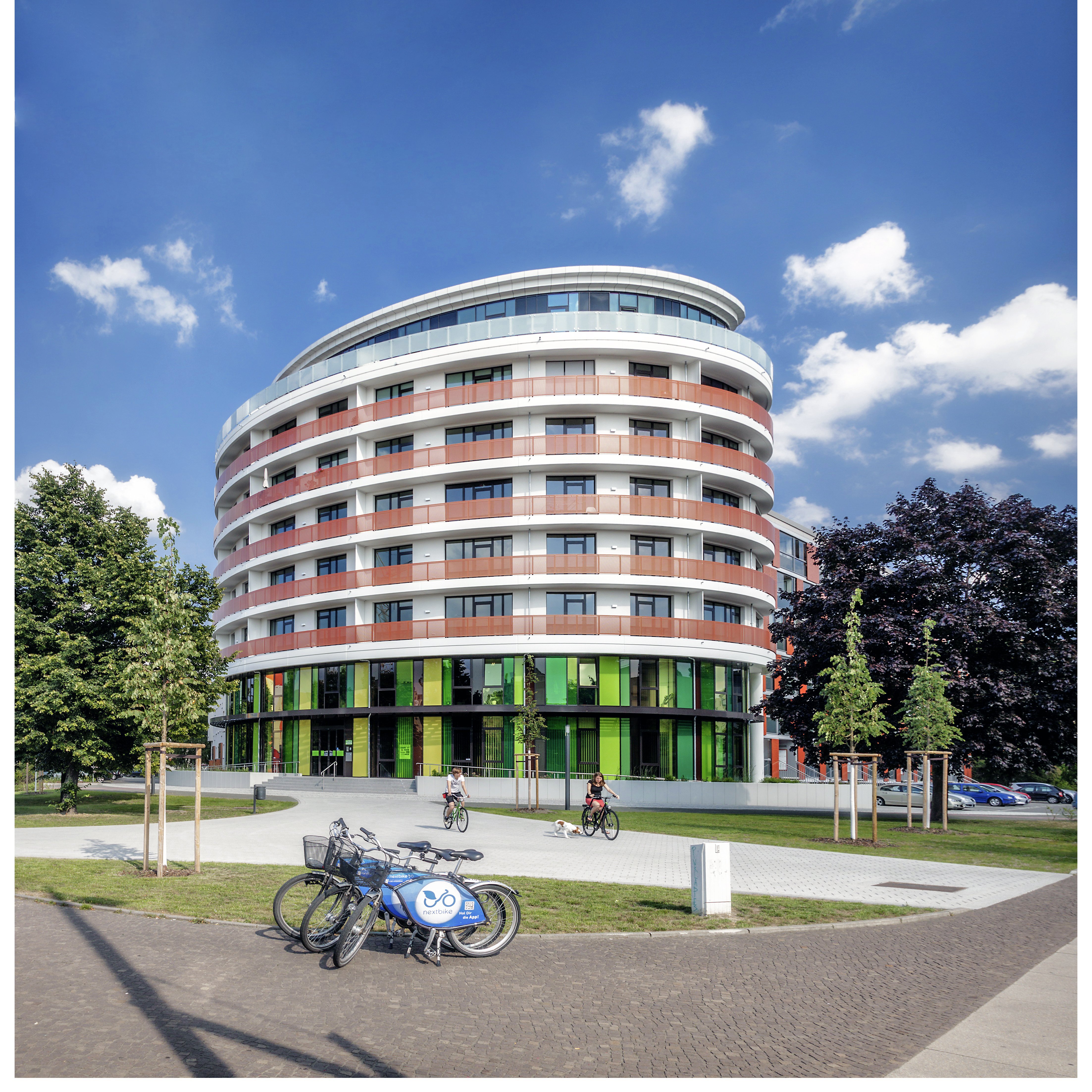 zentrale der UNITAS: ein Gebäude mit einer gewölbten Fassade, Grünfläche im Vordergrund 