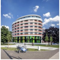 zentrale der UNITAS: ein Gebäude mit einer gewölbten Fassade, Grünfläche im Vordergrund 
