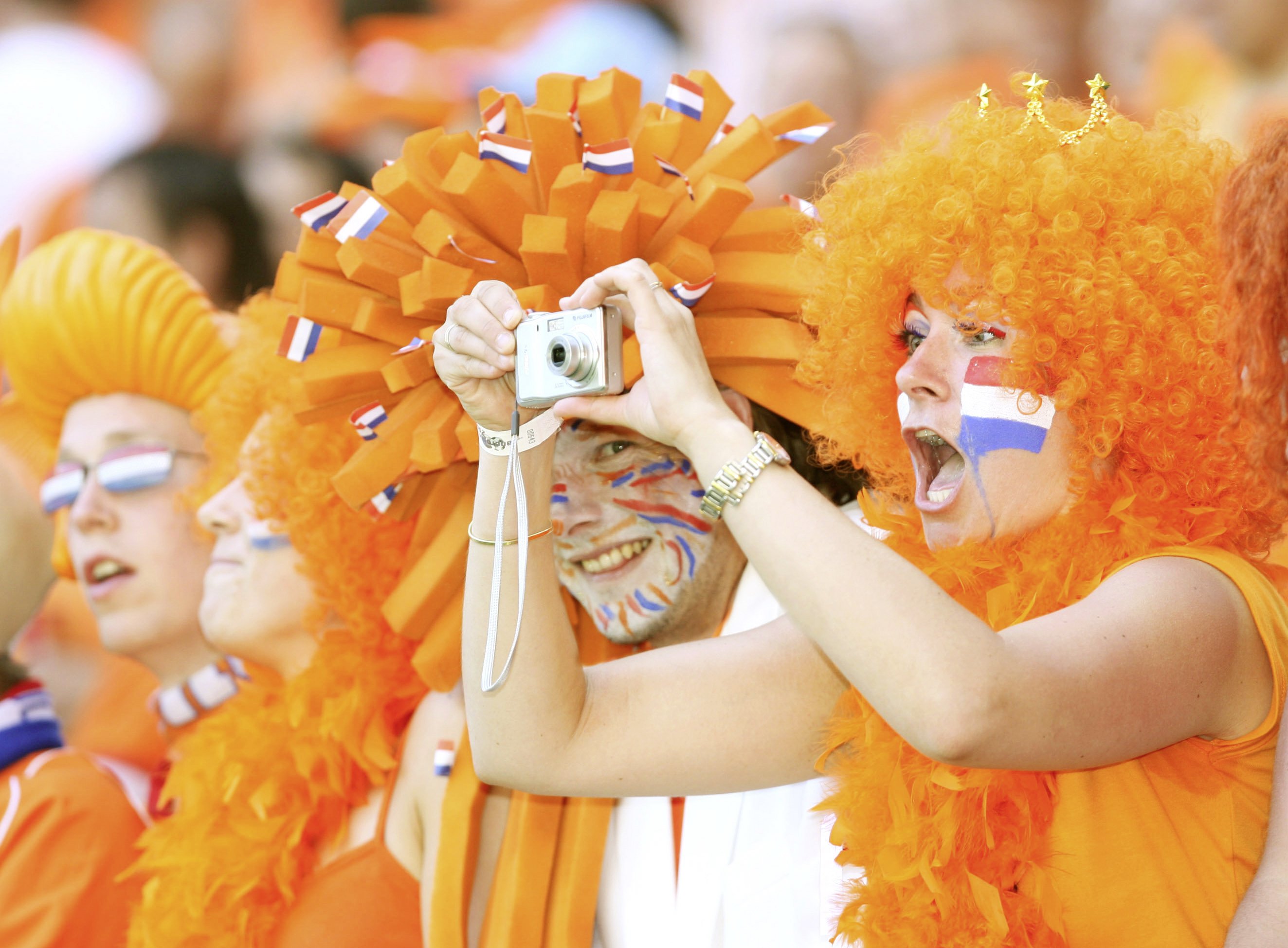 zusehen sind zwei feiernde Fans in den färben der Niederlande (orange) 