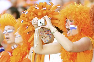 zusehen sind zwei feiernde Fans in den färben der Niederlande (orange) 