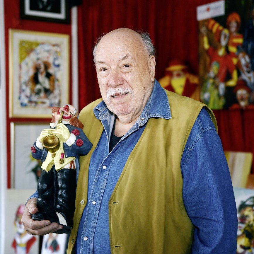 Hans-Dieter Hormann steht mit einem Clown in der Hand in seinem Museum