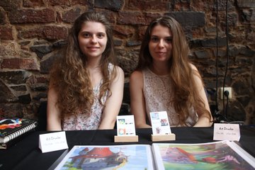 Zwei brünette junge Frauen mit ihrer Kunst