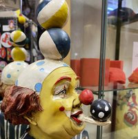 zu sehen ist einen Clownfigur die Bälle auf dem kopf balanciert 