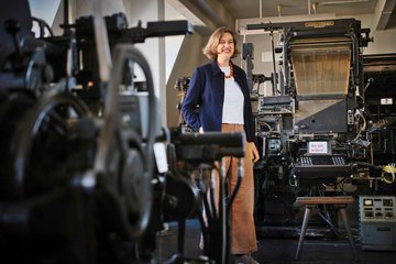 Museumsdirektorin Gunda Luyken begeistert sich für die historischen Setzmaschinen von Linotype im Hintergrund