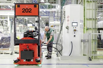 zusehen: ein Moderen Gabelstapler der Rot ist und mit Wasserstoff betankt wird 