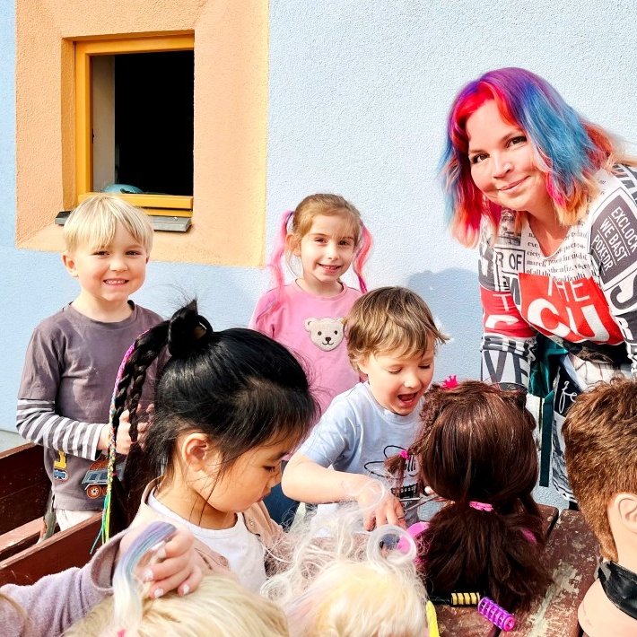 Erzieherin Julia Klingner arbeitet mit ihrer Gruppe an Frisuren und bunten Haaren