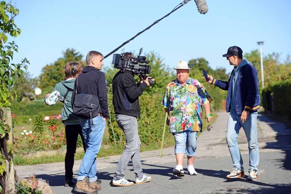 Zwischen Parzellen und Hecken: Michael Baumann mit Produktionsteam beim Dreh in der Anlage