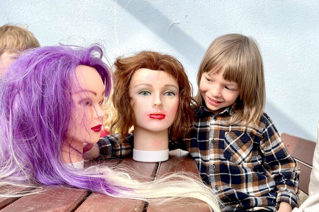 Die Puppengesichter lassen sich geduldig schminken – Erzieherin Julia Klingner (Bild rechts) arbeitet mit ihrer Gruppe an Frisuren und bunten Haaren