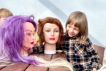 Die Puppengesichter lassen sich geduldig schminken – Erzieherin Julia Klingner (Bild rechts) arbeitet mit ihrer Gruppe an Frisuren und bunten Haaren