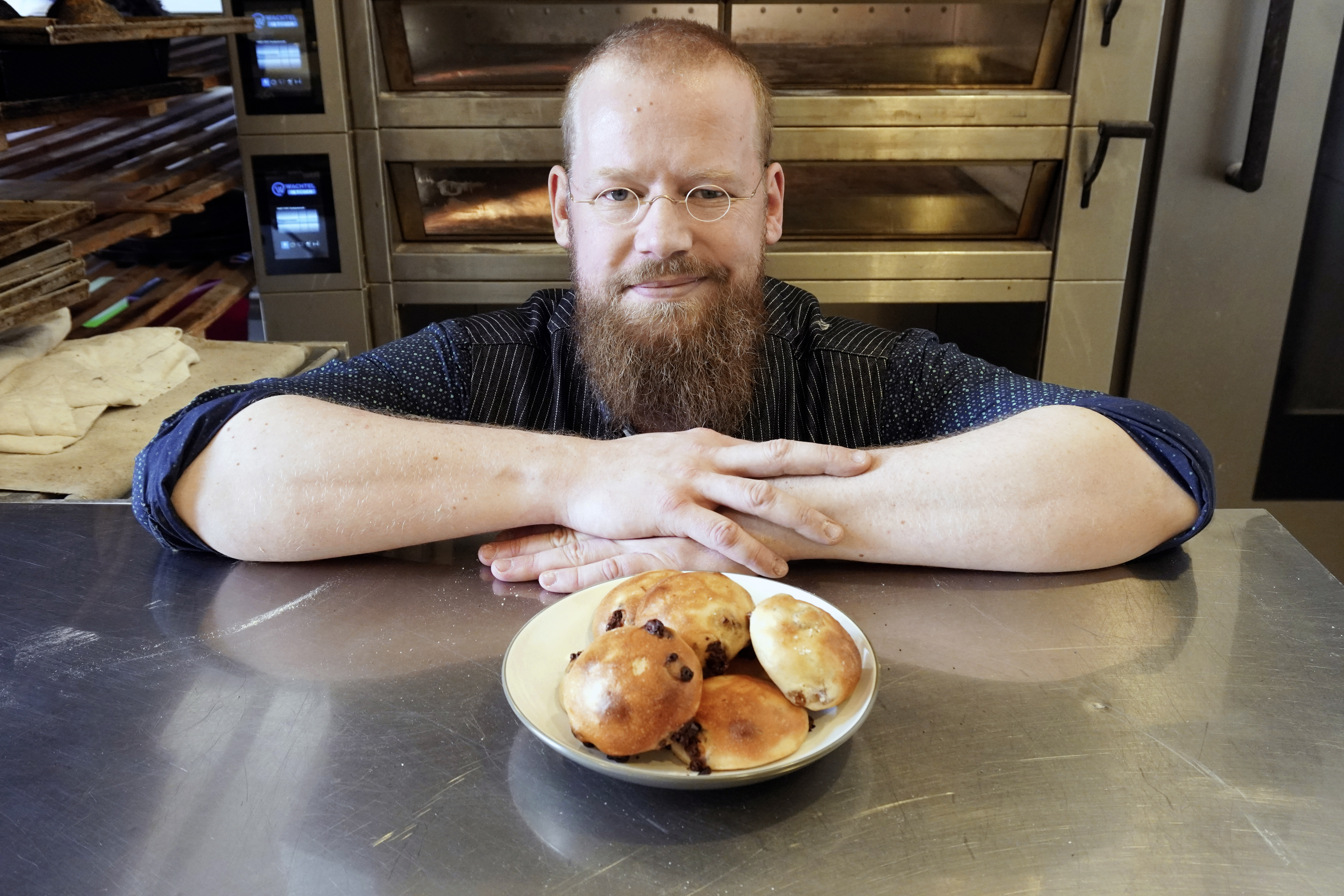 Portrait von Holger Martens in der Backstube, Schokobrötchen im Vordergrund 