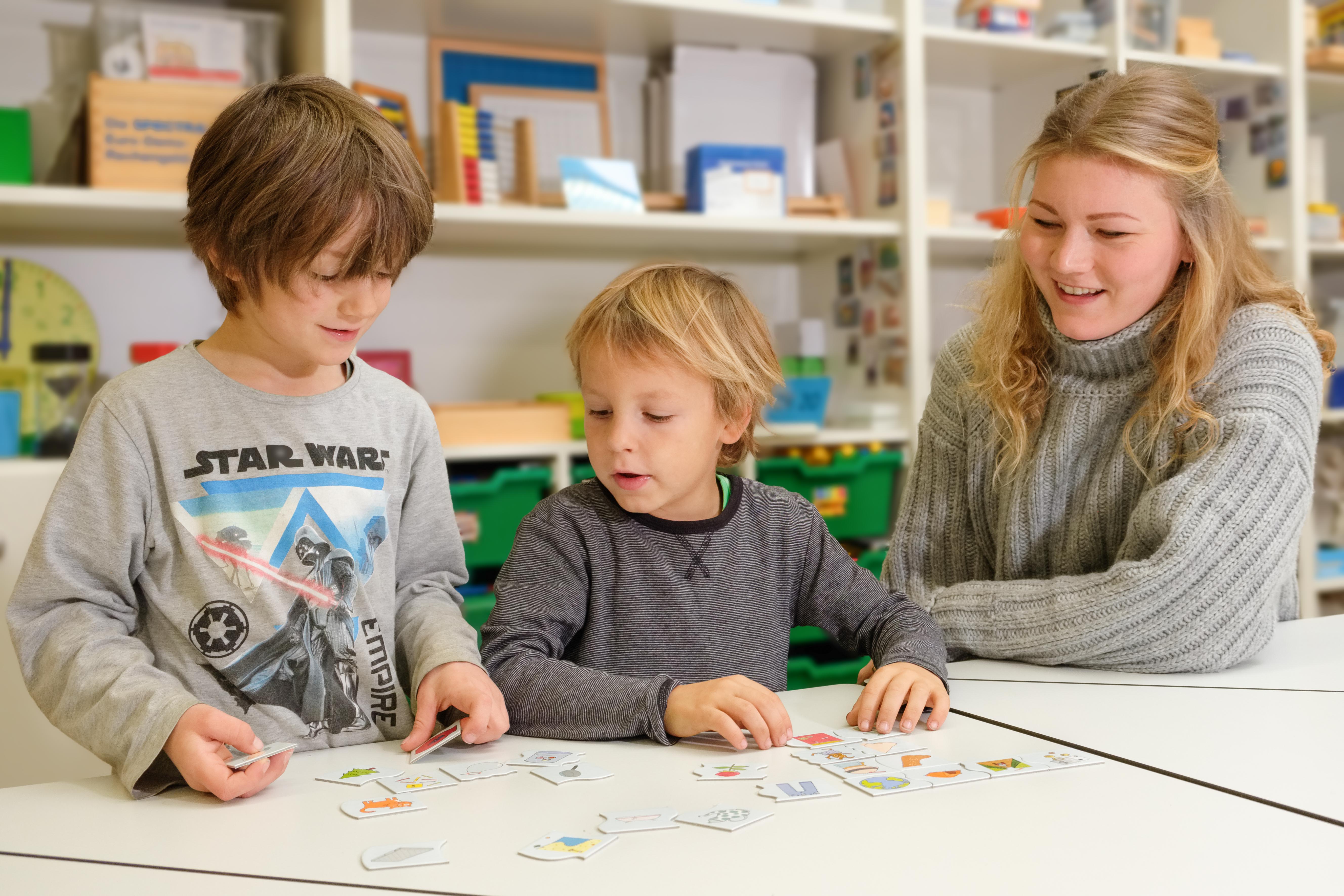 StartTrainerin bei der Arbeit mit zwei Schülern an einer Leipziger Grundschule